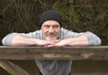 Man leaning against an old wooden gate outdoors Royalty Free Stock Photo