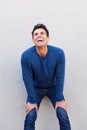 Man leaning against wall with hands on knees and laughing Royalty Free Stock Photo