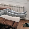 man leaning his legs on a leg elevation pillow Royalty Free Stock Photo