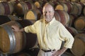 Man Leaning On Wine Cask In Cellar