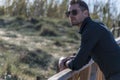 Man leaning on a wooden railing in beach area Royalty Free Stock Photo