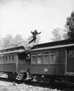 Man leaping across the roof of railroad cars