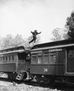 Man leaping across the roof of railroad cars Royalty Free Stock Photo