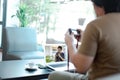 Asian male watching online training workshops for camera function by notebook in the living room