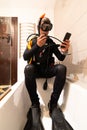 A man learns through online lessons with his smartphone to dive, in the bathtub of his house. Home confinement Royalty Free Stock Photo