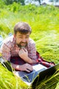 Man learns, working on laptop lying on meadow. mobile Internet in rural