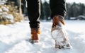 Man in leather brown winter boots walking on snowy road outdoors, back view. Close-up of modern warm men\'s shoes