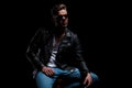 Man in leather jacket sits and looks up to side Royalty Free Stock Photo