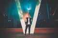 Man in a leather jacket standing at the street with smoke bomb. Colorful portrait of european teenager with blue smoke bomb