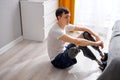 man with leg amputated put on a fake leg and sat on the floor at home, looking sad Royalty Free Stock Photo