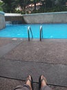 Man legs is relaxing in the beautiful view of pool in the resort