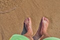 Man legs on the sand beach and sea waves at sunset Royalty Free Stock Photo