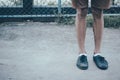 A man legs wearing black canvas shoes and brown pants standing on concrete ground with copy space Royalty Free Stock Photo