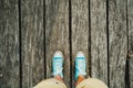 Man Legs in Shorts and Blue Shoes on Wooden Pier at Sunset. Top view Royalty Free Stock Photo