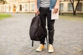 Man legs in yellow sneakers, wearing grey t-shirt, black skinny jeans at university campus in autumn. Front view of stylish man st Royalty Free Stock Photo