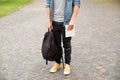 Man legs in yellow sneakers, wearing grey t-shirt, black skinny jeans at university campus in autumn. Royalty Free Stock Photo
