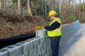 A man leveled a concrete block wall that was being built with the aid of his leveling tool