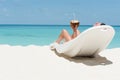 Man lie on lounger sunbed and drink coconut cocktail on beach wi