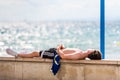 The man lies on the seafront in Salou, Tarragona, Spain.