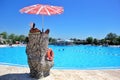 Man Lifeguard sitting on the chair under the sun umbrella near the swimming pool Royalty Free Stock Photo