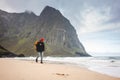 Alone brave male tourist standing in front of ord sea and great mountain rock