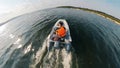 A man in a lifevest is onboard of the motorboat