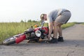 A man lifts a motorcycle that fell after an accident