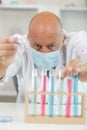 man lifts test-tube up at laboratory