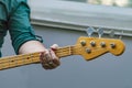 Man in light shirt plays bass guitar.