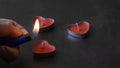 a man with a lighter lights candles in the form of hearts for valentine& x27;s day