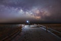Man lighting a beach path as the Milky Way rises