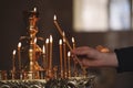 Man lighting candle near stand in church, closeup. Baptism ceremony Royalty Free Stock Photo