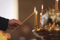 Man lighting candle near stand in church, closeup. Baptism ceremony Royalty Free Stock Photo