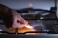 A man lights a gas stove with a match Royalty Free Stock Photo