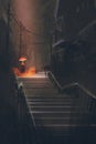 Man with lights umbrella standing on stair in the night rain