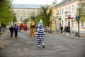 A man in a lion and zebra costume on a city street greets passers-by. Advertising on the street. Work in advertising