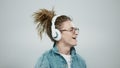 Man listening music in headphones. Guy dancing in earphones on grey background Royalty Free Stock Photo