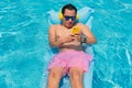 Man listening to music and holding a mobile phone in the pool Royalty Free Stock Photo