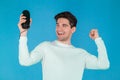 Man listening to music by wireless portable speaker - modern sound system. Young guy dancing, enjoying at blue studio Royalty Free Stock Photo