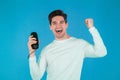 Man listening to music by wireless portable speaker - modern sound system. Young guy dancing, enjoying at blue studio Royalty Free Stock Photo