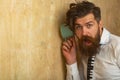 Man listening through the wall with the cup. Secrets and gossip concept. Neighbour and secret. Funny man with beard hear Royalty Free Stock Photo