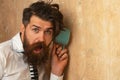 Man listening through the wall with the cup. Secrets and gossip concept. Neighbour and secret. Funny man with beard hear Royalty Free Stock Photo