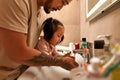 Man and little daughter wash hands in wash basin