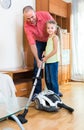 Man and little girl hoovering at home Royalty Free Stock Photo