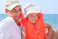 Man with little girl in orange lifejacket on beach Royalty Free Stock Photo