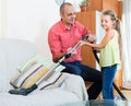 Man and little girl vacuuming at home Royalty Free Stock Photo