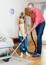 Man and little girl vacuuming at home Royalty Free Stock Photo