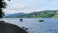 Man in green with green umbrella sits in green boat on Lake Titisee in the Black Forest, Germany