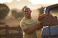 Man Loading Backpack Into Pick Up Truck For Road Trip To Cabin In Countryside Royalty Free Stock Photo