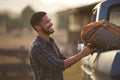 Man Loading Backpack Into Pick Up Truck For Road Trip To Cabin In Countryside Royalty Free Stock Photo